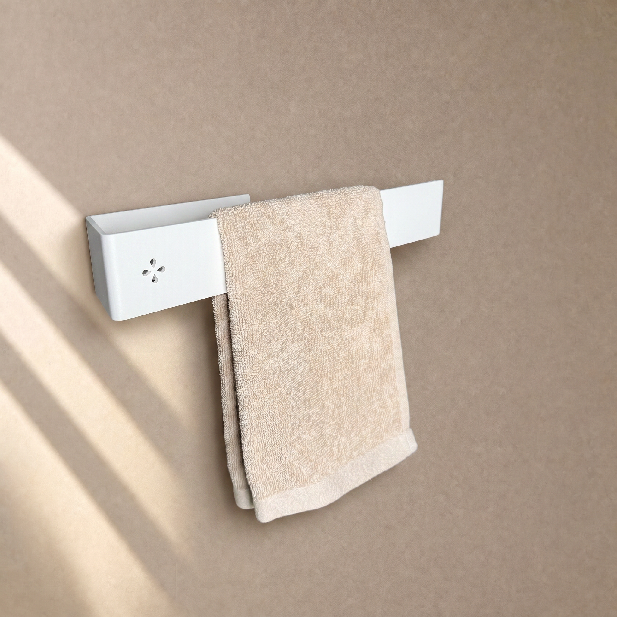 Einarmiger Handtuchhalter in Weiß matt an der Wand, mit beigem Handtuch behängt