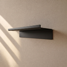 Leere Duschablage gerade in Schwarz matt von schräg unten an der Wand