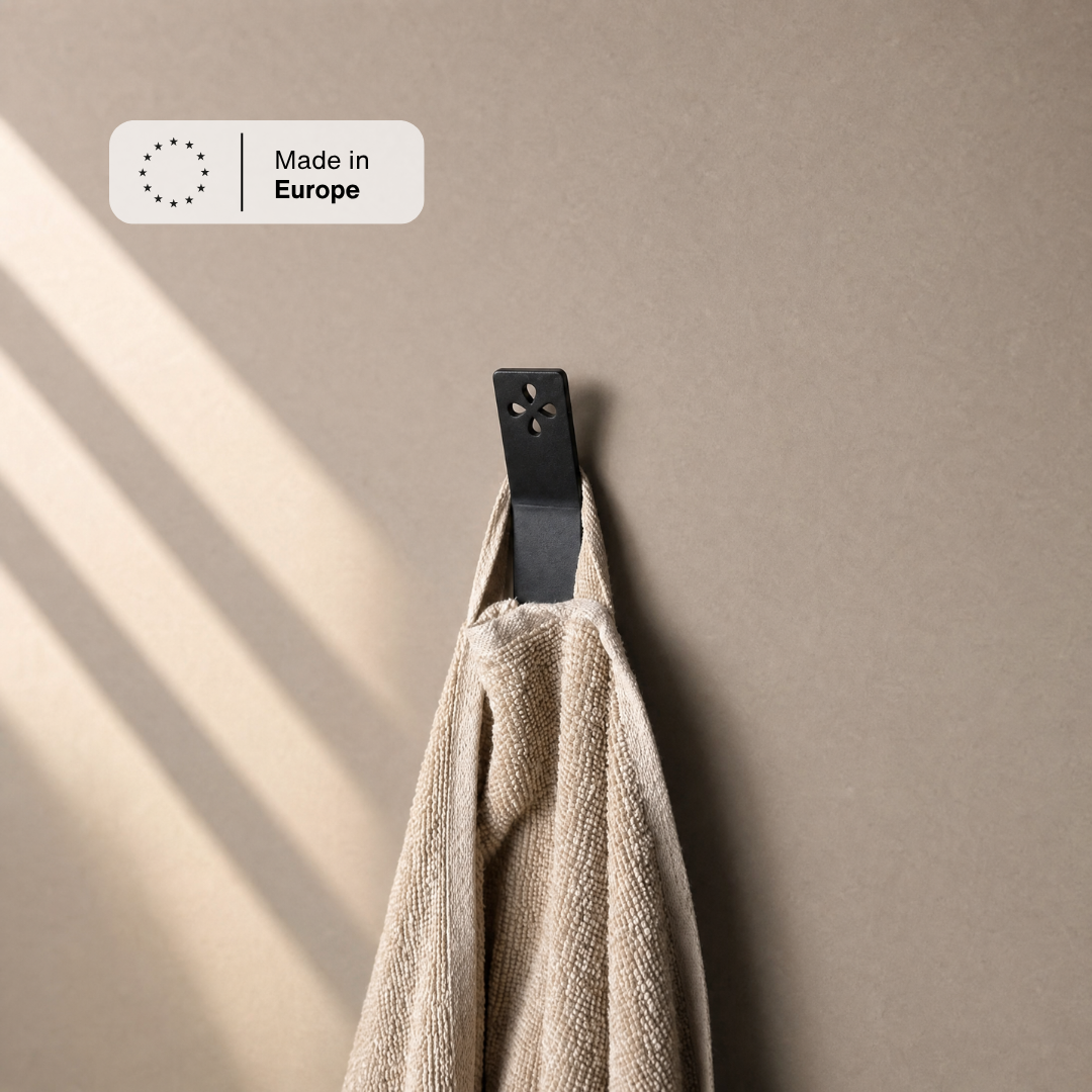 Wandhaken Schwarz mit beigem Handtuch im Sonnenlicht, Hinweis Made in Europe