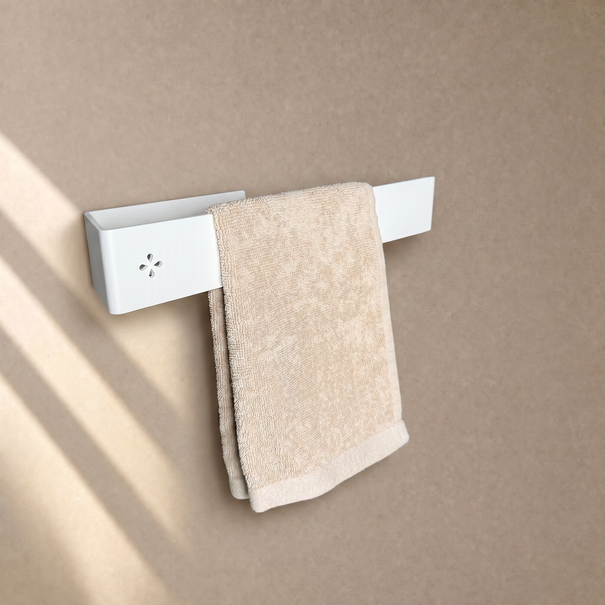 Einarmiger Handtuchhalter in Weiß matt an der Wand, mit beigem Handtuch behängt