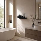 Schwarzes Wandregal mit Raumduft und Handtücher über einer Badewanne